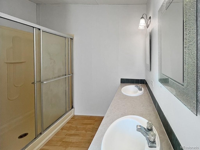 bathroom featuring vanity, hardwood / wood-style flooring, and a shower with door