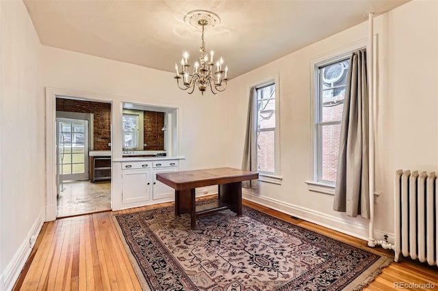 2122 E 13th Ave, Denver, CO 80206 - dining room featuring radiator heating unit, plenty of natural light, a chandelier, and light wood-type flooring