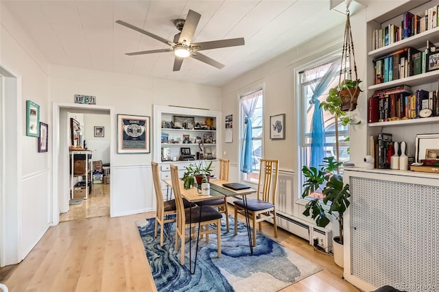 2122 E 13th Ave, Denver, CO 80206 - dining room featuring a baseboard heating unit, a ceiling fan, and light wood-style floors