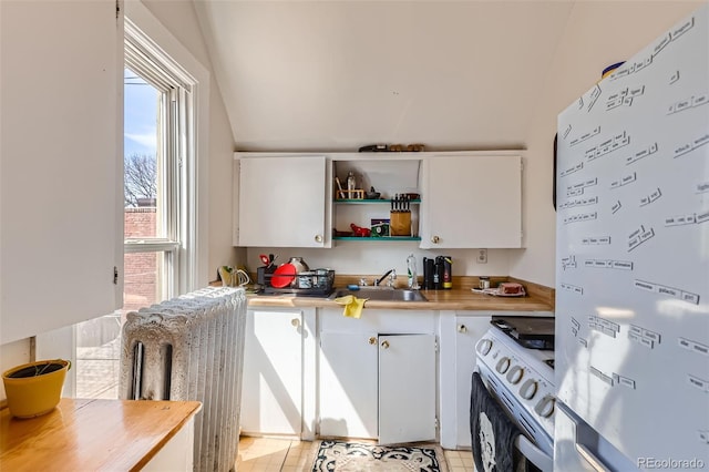 2122 E 13th Ave, Denver, CO 80206 - kitchen featuring lofted ceiling, freestanding refrigerator, white range with gas cooktop, and a sink