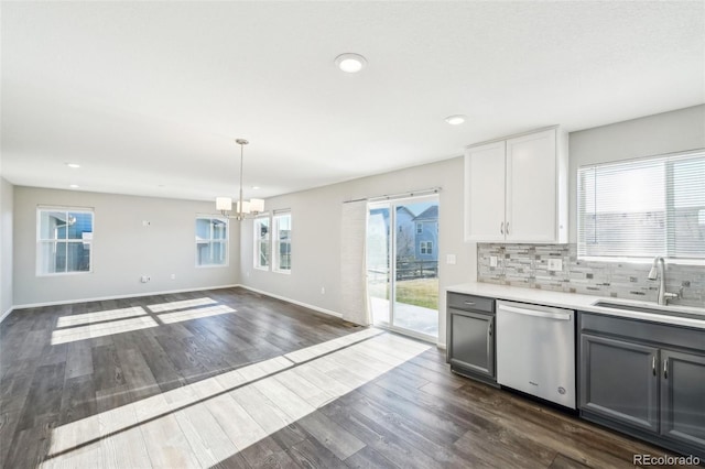 kitchen featuring stainless steel dishwasher, dark hardwood / wood-style floors, sink, and hanging light fixtures