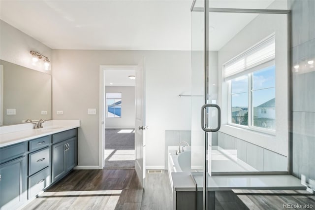 bathroom featuring a tub to relax in, vanity, and hardwood / wood-style flooring