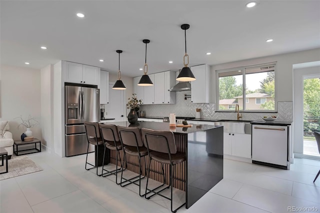 7684 S Ingalls St, Littleton, CO 80128 - kitchen featuring stainless steel refrigerator with ice dispenser, dishwasher, dark countertops, backsplash, and a center island