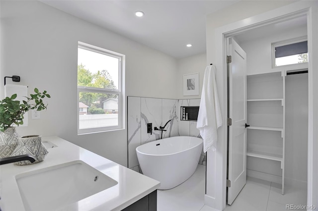 7684 S Ingalls St, Littleton, CO 80128 - full bath with a soaking tub, double vanity, tile patterned floors, and recessed lighting