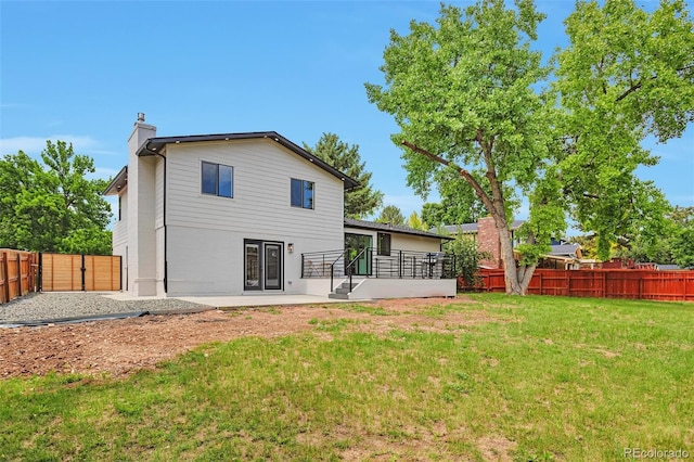 7684 S Ingalls St, Littleton, CO 80128 - back of property with a chimney, a patio, a fenced backyard, and french doors
