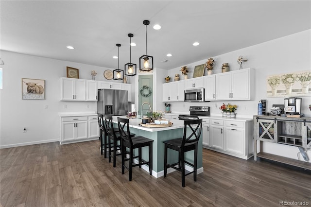 kitchen with white cabinetry, dark hardwood / wood-style flooring, an island with sink, and stainless steel appliances