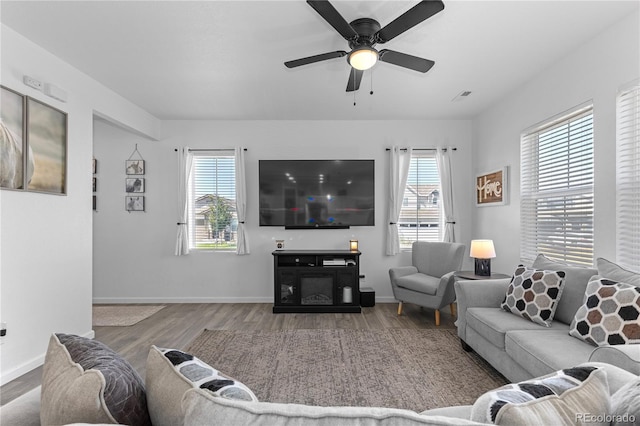 living room with hardwood / wood-style flooring, ceiling fan, and a wealth of natural light