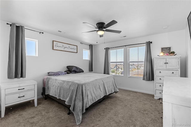 carpeted bedroom with multiple windows and ceiling fan