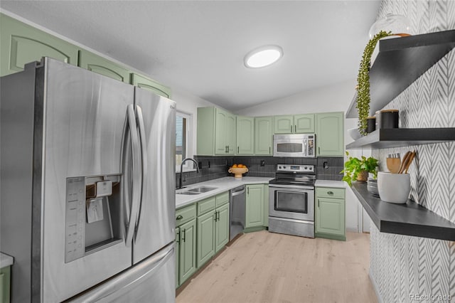kitchen featuring green cabinets, open shelves, appliances with stainless steel finishes, a sink, and lofted ceiling