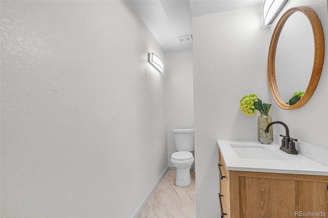 half bath featuring vanity, visible vents, marble finish floor, and toilet