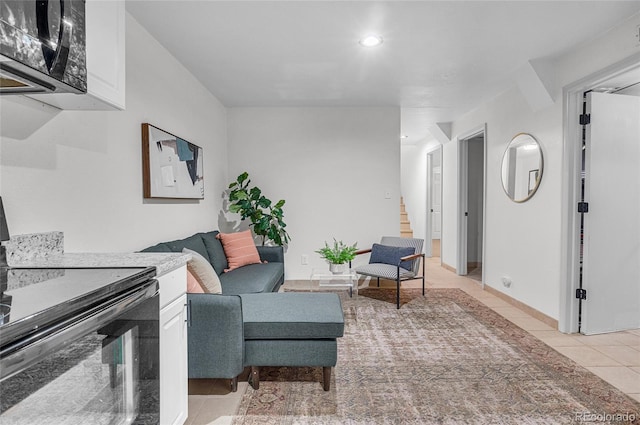 sitting room featuring light tile patterned floors, recessed lighting, and stairs