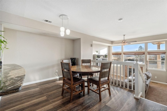 dining room featuring dark wood-type flooring, a textured ceiling, and ceiling fan