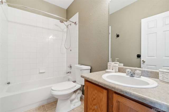 full bathroom featuring tiled shower / bath, vanity, and toilet