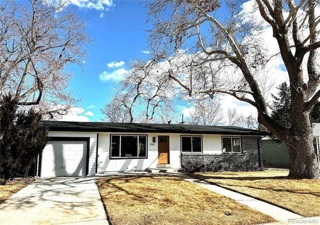 ranch-style house with an attached garage, a front yard, concrete driveway, and brick siding