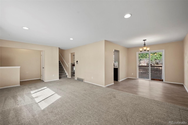 unfurnished room with hardwood / wood-style flooring and a chandelier