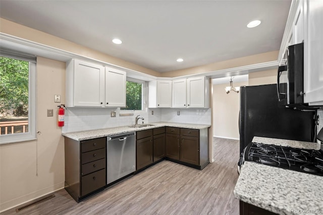 kitchen with white cabinetry, sink, stainless steel dishwasher, and light hardwood / wood-style floors