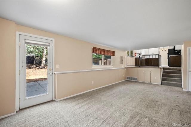 unfurnished living room featuring light carpet