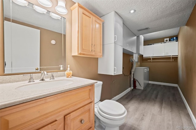 bathroom featuring toilet, vanity, a textured ceiling, and hardwood / wood-style flooring