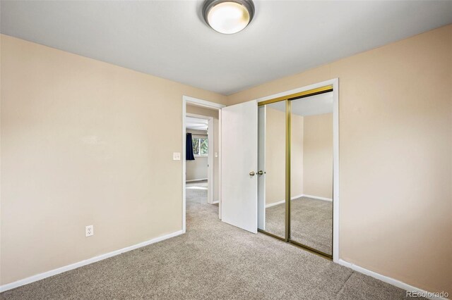 unfurnished bedroom with carpet flooring and a closet