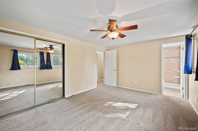 unfurnished bedroom featuring carpet flooring, ensuite bathroom, a closet, and ceiling fan