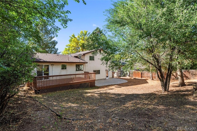 rear view of property featuring a patio and a wooden deck