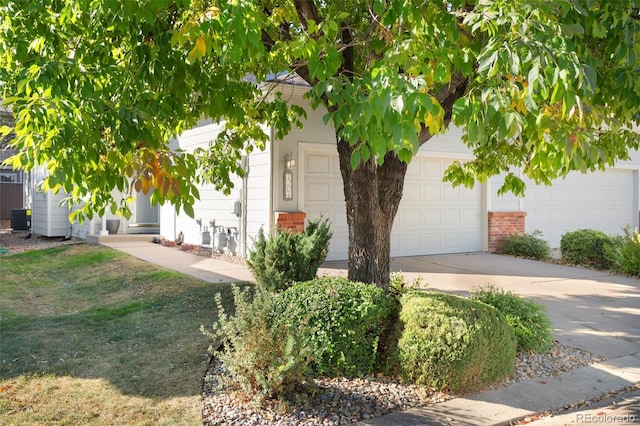 obstructed view of property featuring a front yard and a garage