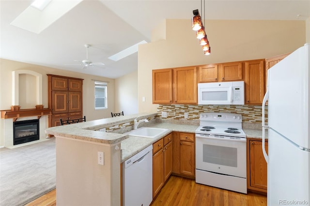 kitchen with light wood-type flooring, ceiling fan, white appliances, decorative light fixtures, and kitchen peninsula