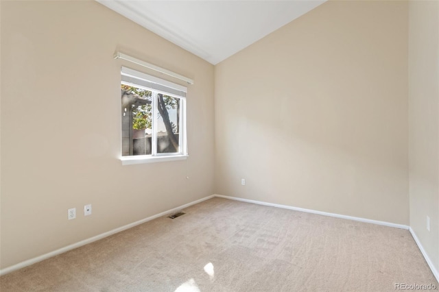 unfurnished room featuring light carpet and lofted ceiling