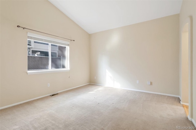 unfurnished room with lofted ceiling and light carpet