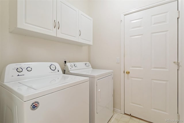 laundry room with washing machine and dryer and cabinets