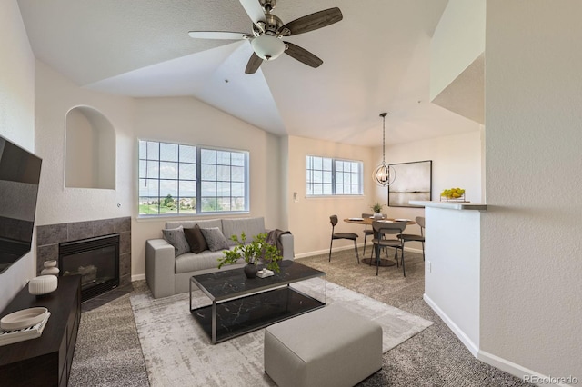 5705 N Genoa Way Unit 308, Aurora, CO 80019 - living room with vaulted ceiling, carpet, a tiled fireplace, ceiling fan, and baseboards