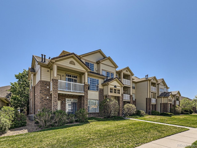 5705 N Genoa Way Unit 308, Aurora, CO 80019 - townhome / multi-family property featuring brick siding, a front lawn, and a residential view