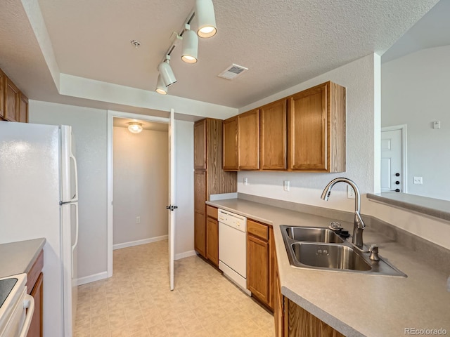 5705 N Genoa Way Unit 308, Aurora, CO 80019 - kitchen featuring a sink, white appliances, brown cabinets, light flooring, and rail lighting