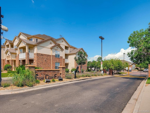 5705 N Genoa Way Unit 308, Aurora, CO 80019 - view of asphalt street with curbs, a gate, street lighting, and a gated entry