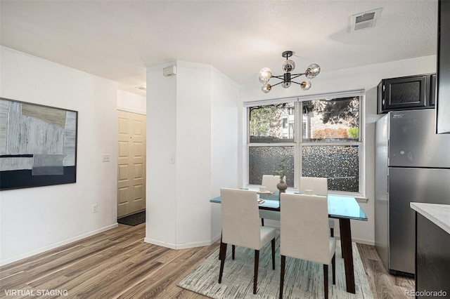 8035 W Eastman Pl Unit 106, Lakewood, CO 80227 - dining space featuring light wood-type flooring, a chandelier, and baseboards