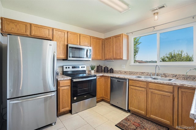 4585 Jet Wing Cir, Colorado Springs, CO 80916 - kitchen featuring appliances with stainless steel finishes, a sink, light tile patterned floors, and light countertops