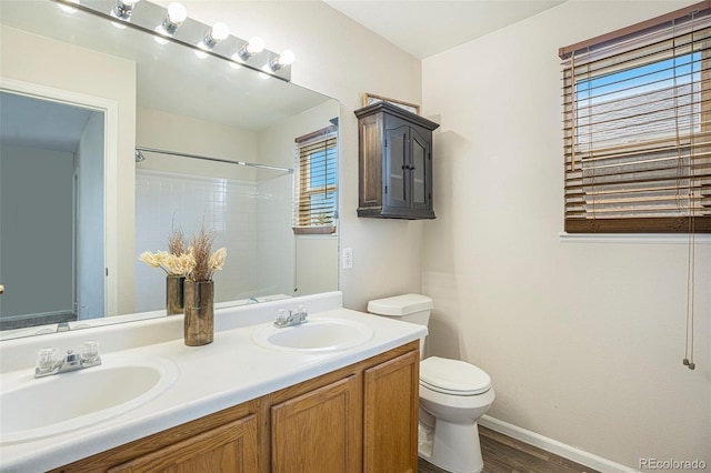 4585 Jet Wing Cir, Colorado Springs, CO 80916 - full bathroom with toilet, wood finished floors, double vanity, baseboards, and a shower