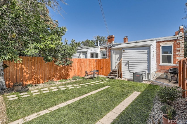 rear view of house with a lawn and central air condition unit