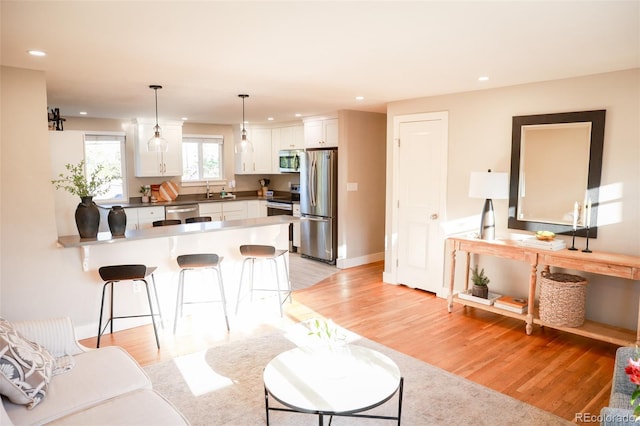 7100 Saulsbury St, Arvada, CO 80003 - living room featuring light wood-style floors, recessed lighting, and baseboards