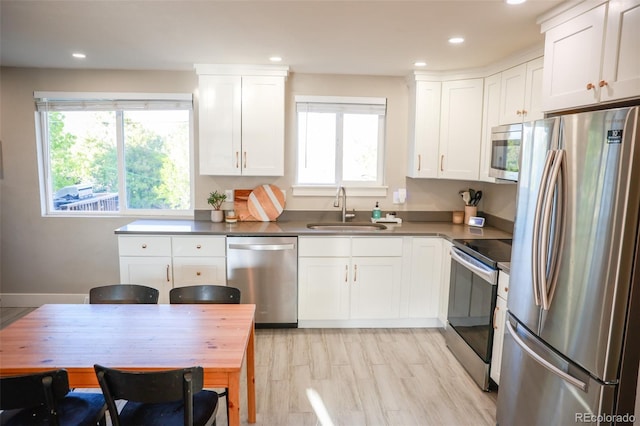 7100 Saulsbury St, Arvada, CO 80003 - kitchen with appliances with stainless steel finishes, a sink, white cabinetry, recessed lighting, and dark countertops