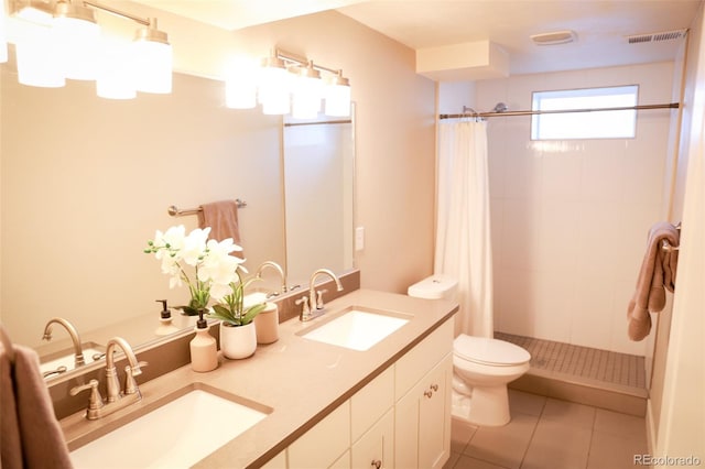 7100 Saulsbury St, Arvada, CO 80003 - full bathroom with toilet, a tile shower, double vanity, and tile patterned flooring