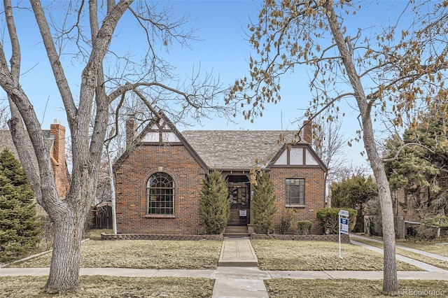 english style home featuring a front yard