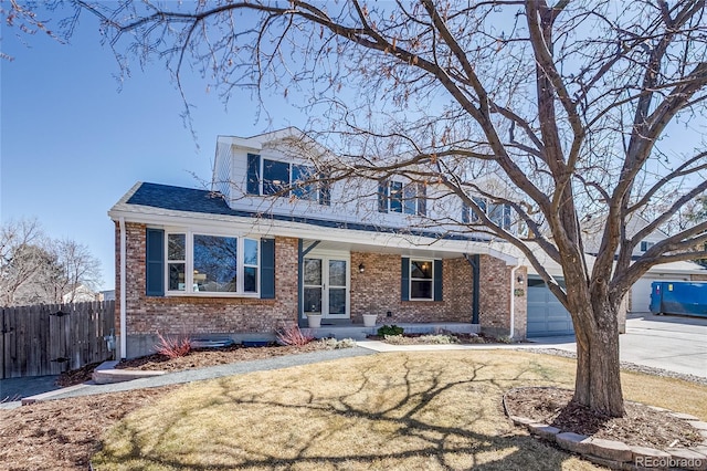 view of front of house featuring a front yard, concrete driveway, brick siding, and fence