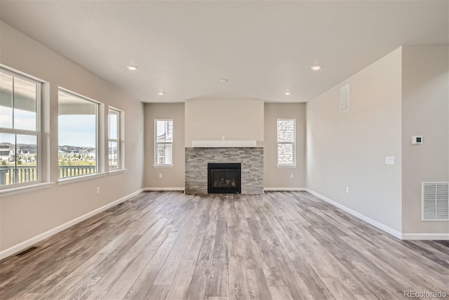 unfurnished living room featuring a fireplace and light hardwood / wood-style flooring