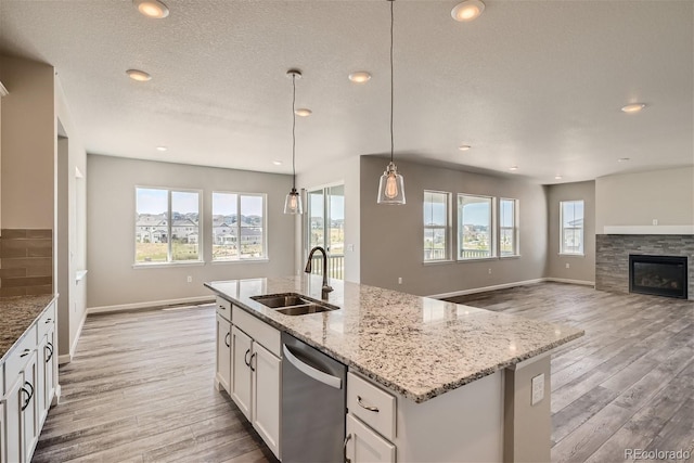 kitchen featuring white cabinetry, stainless steel dishwasher, plenty of natural light, and sink