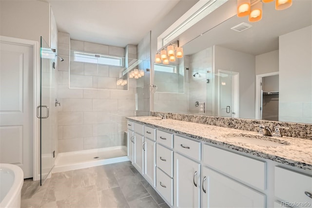 bathroom featuring tile patterned flooring, vanity, and walk in shower