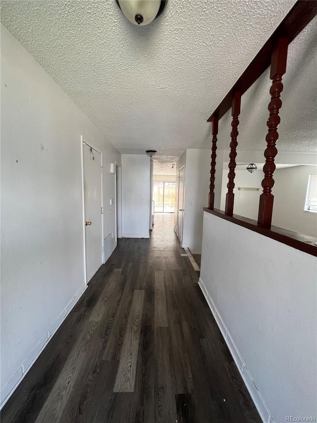 hallway featuring a textured ceiling and dark wood-type flooring