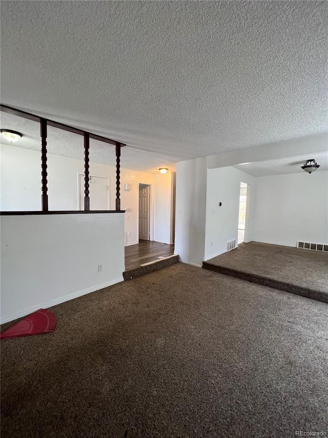 carpeted spare room with a textured ceiling