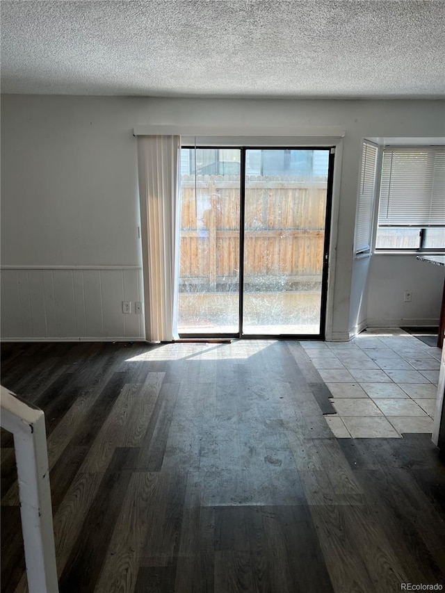 unfurnished room with a textured ceiling and hardwood / wood-style flooring