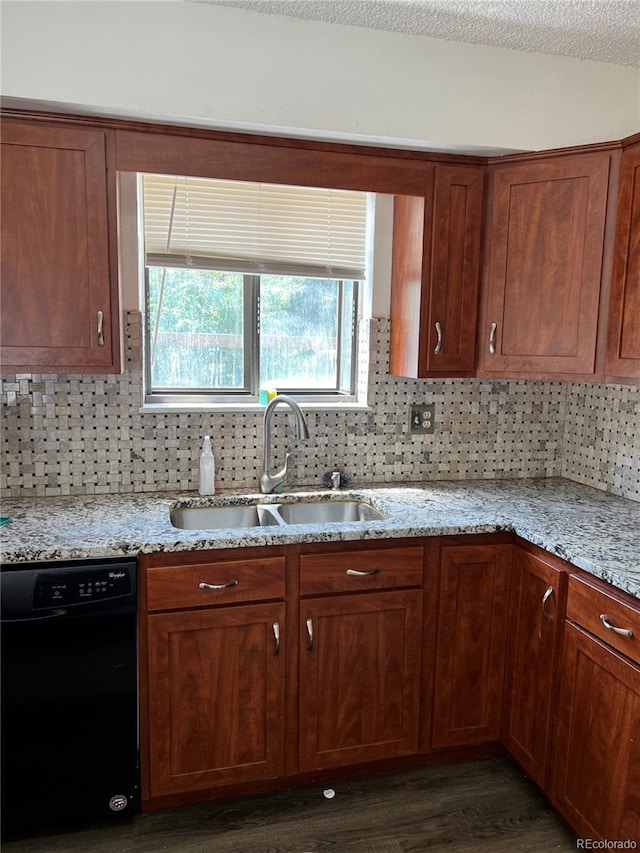 kitchen featuring light stone countertops, sink, dark wood-type flooring, black dishwasher, and backsplash